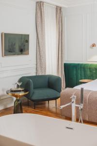 ein Wohnzimmer mit einem grünen Sofa und einem Bett in der Unterkunft Hôtel Singulier Bordeaux in Bordeaux