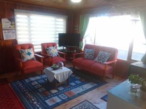 a living room with two red chairs and a table at Cabaña Dalcahue Avenida Mocopulli in Dalcahue
