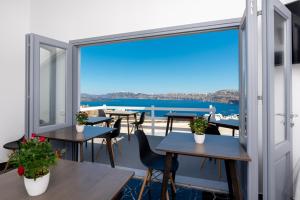 a view from the balcony of a restaurant with tables and chairs at Pancratium Villas & Suites in Akrotiri