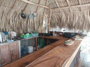 a kitchen with a wooden counter top in a hut at Hostel Nugeku in Rincón