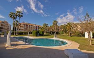 a swimming pool in a park with palm trees at Villa privada a 350 metros del mar ALCOSSEBRE Albert Villas in Alcossebre