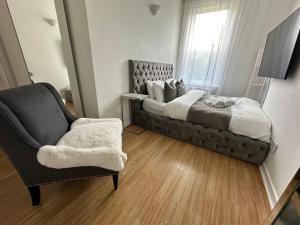 um quarto com uma cama, uma cadeira e uma janela em 5 min from the beach ,parking in Guest House em Bournemouth