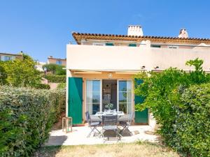 a patio with a table and chairs in front of a house at Apartment Le Petit Village-1 by Interhome in Les Issambres