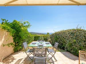 - une table et des chaises sur la terrasse d'une maison dans l'établissement Apartment Le Petit Village-1 by Interhome, aux Issambres