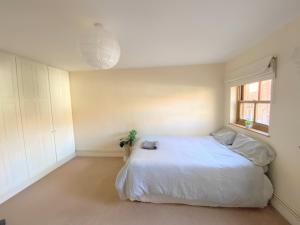 a bedroom with a white bed and a window at Cozy Double Room next to Putney Bridge and High Street in London