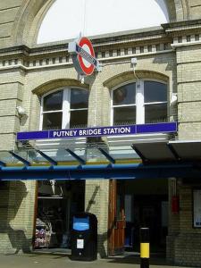 un edificio con una señal de estación de puente púrpura en él en Cozy Double Room next to Putney Bridge and High Street en Londres