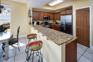 uma cozinha com um balcão, um frigorífico e uma mesa em Sea Dunes 504 condo em Fort Walton Beach