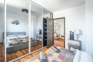 a bedroom with two beds and a mirror at Apartament Kaskada Parking & Balcony by Axel in Gdynia
