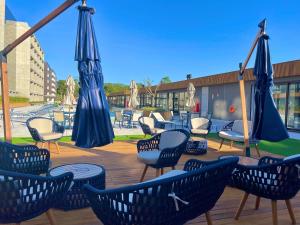 une terrasse avec des chaises, des tables et des parasols dans l'établissement Livin' Resort Home - 505/2, à Xangri-lá