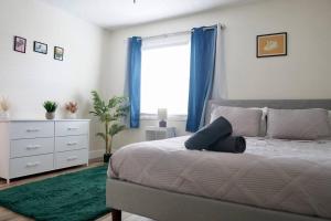 a bedroom with a bed and a dresser and a window at Jay's Cozy Arts in Tampa