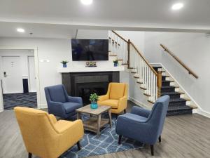 a living room with chairs and a fireplace at Travelodge Suites by Wyndham Saint John in Saint John