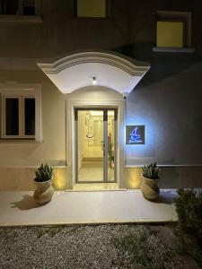 una porta d'ingresso di una casa con due piante in vaso di Blue Marine a Tropea