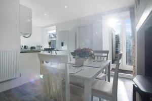 a white dining room with a white table and chairs at Feels like Home in Bishop, with Backyard, Sleeps 3 in Bishop Auckland