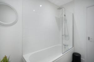 a white bathroom with a shower and a mirror at Feels like Home in Bishop, with Backyard, Sleeps 3 in Bishop Auckland