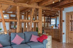 a living room with a blue couch and a kitchen at Landhaus Seewald in Seewald