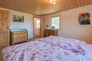 1 dormitorio con 1 cama grande y techo de madera en Landhaus Seewald, en Seewald