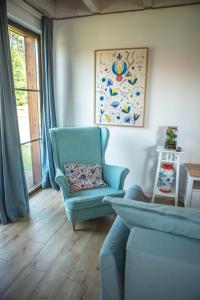 uma sala de estar com uma cadeira azul e uma janela em Biały Bez Ostoja Bukowo em Borowy Młyn