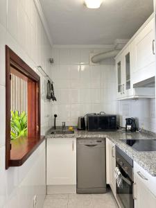 馬貝拉的住宿－Tropical Old Town Marbella，白色的厨房配有水槽和微波炉
