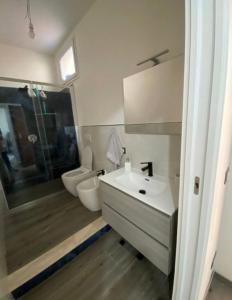 ein Badezimmer mit einem weißen Waschbecken und einem WC in der Unterkunft La conchiglia sul mare in Mazara del Vallo