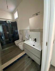 a bathroom with a white sink and a toilet at La conchiglia sul mare in Mazara del Vallo