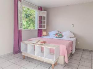 a bedroom with a bed with a pink blanket and a window at VILLAS AUMIS 2MR in Fort-de-France