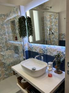 een badkamer met een wastafel en een spiegel bij Orchidea in Modena