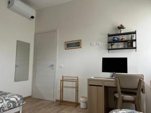 een slaapkamer met een bureau, een computer en een bed bij Orchidea in Modena