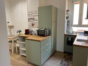 a kitchen with a counter with a microwave and a refrigerator at Orchidea in Modena