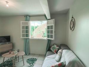 1 dormitorio con cama, mesa y ventana en VILLAS AUMIS 2MR en Fort-de-France