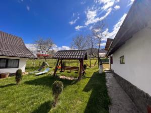 a yard with a swing set and a house at Cozy House Zărnești in Predeluţ