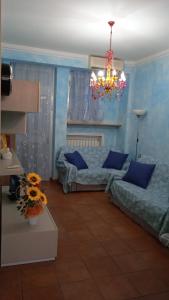 a living room with two beds and a chandelier at Casa vacanza Leonida in Carrara