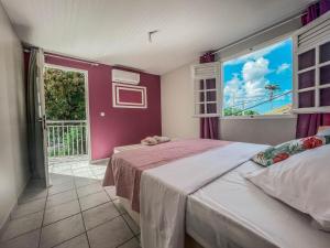 a bedroom with two beds and a large window at VILLAS AUMIS 2MR in Fort-de-France