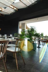 a restaurant with tables and chairs and potted plants at Luxury Menlyn Maine Apartment in Pretoria