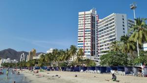 un grupo de personas en una playa con edificios en Balcón del Rodadero, en Santa Marta