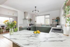 a kitchen with a counter with a bowl of fruit on it at Beautiful Modern Home In Dingle 5 min walk to town in Dingle