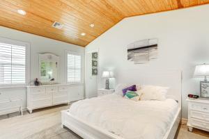 a bedroom with a white bed and a wooden ceiling at Waterfront Stuart Oasis with Hot Tub and Dock! in Stuart