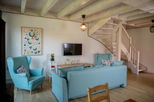een woonkamer met een blauwe bank en een trap bij Biały Bez Ostoja Bukowo in Borowy Młyn