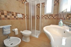 uma casa de banho com um WC, um lavatório e um chuveiro em Villetta Assunta em Capilungo