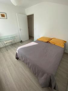 ein Schlafzimmer mit einem großen Bett in einem weißen Zimmer in der Unterkunft Maison de 2 chambres avec jardin clos et wifi a Briscous in Briscous