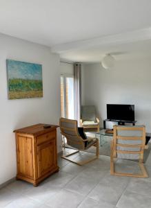 ein Wohnzimmer mit 2 Stühlen und einem Tisch in der Unterkunft Maison de 2 chambres avec jardin clos et wifi a Briscous in Briscous
