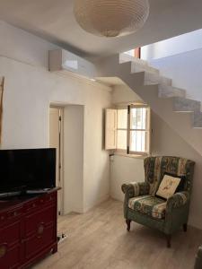 ein Wohnzimmer mit einem Stuhl und einer Treppe in der Unterkunft Fint litet hus i hjärtat av gamla stan och nära hav in Salobreña + 31 Fotos