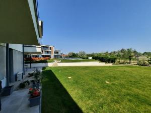un cortile verde accanto a un edificio con prato di Coastline Balaton Apartment ad Alsóörs