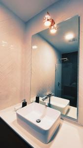 y baño con lavabo blanco y espejo. en Luxury Penthouse Guatemala zona 10, en Guatemala