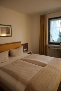 a hotel room with two beds and a window at Hotel Gasthaus zur Linde in Seevetal