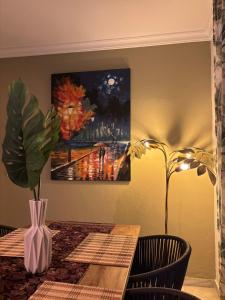 a dining room table with a vase and a painting at Tropical Old Town Marbella in Marbella