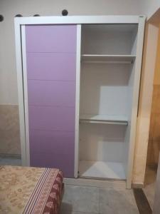 a empty closet with a purple door and shelves at Residencial Barbosa - Apto 102 in Macaé