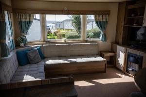 a living room with a couch and a large window at Littlesea Caravan in Weymouth