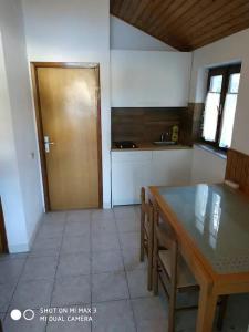 a kitchen with a table and a wooden door at Apartment Zaglav 2 - first sea row in Zaglav +11 photos