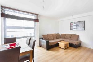 a living room with a couch and a table at Spacious 2 Bedroom Apartment In Central Near tube in London