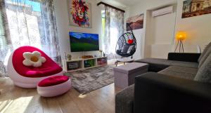 a living room with a couch and a red chair at City Center Apartment - Sleeps 4 in Šibenik